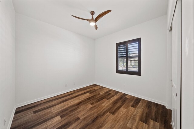 empty room with dark wood-type flooring and ceiling fan