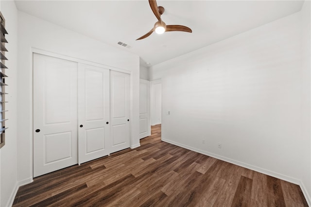 unfurnished bedroom featuring dark wood-type flooring, a closet, and ceiling fan