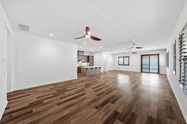 unfurnished living room featuring dark hardwood / wood-style flooring and ceiling fan