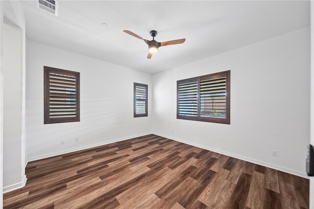 spare room with ceiling fan and dark hardwood / wood-style flooring