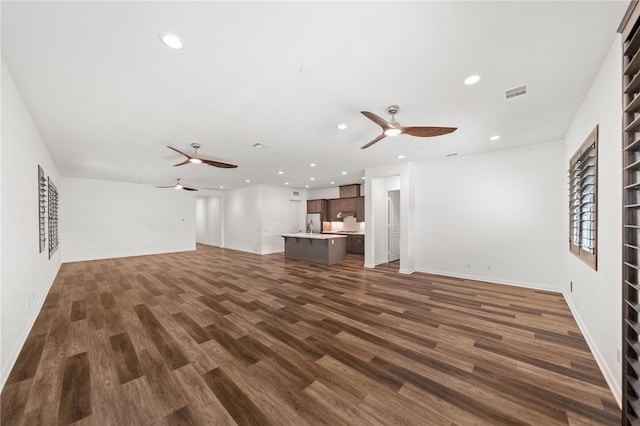 unfurnished living room with ceiling fan and dark hardwood / wood-style flooring