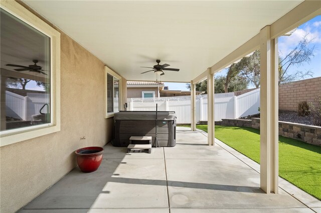 view of patio / terrace with ceiling fan and a hot tub