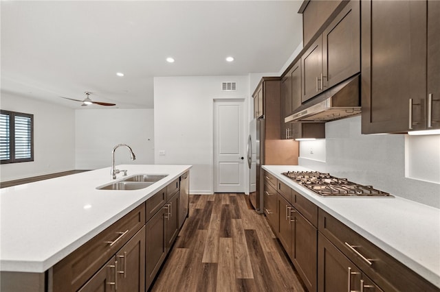 kitchen featuring appliances with stainless steel finishes, sink, dark hardwood / wood-style flooring, dark brown cabinetry, and ceiling fan