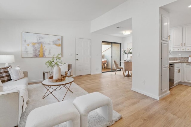 living room with vaulted ceiling and light wood-type flooring