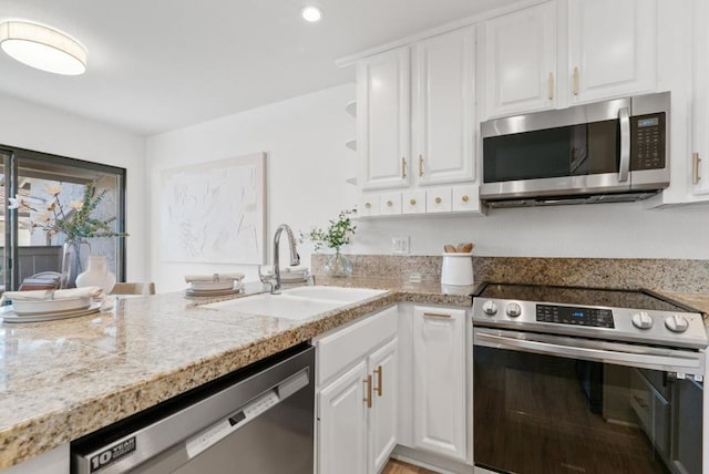 kitchen with stainless steel appliances, sink, and white cabinets