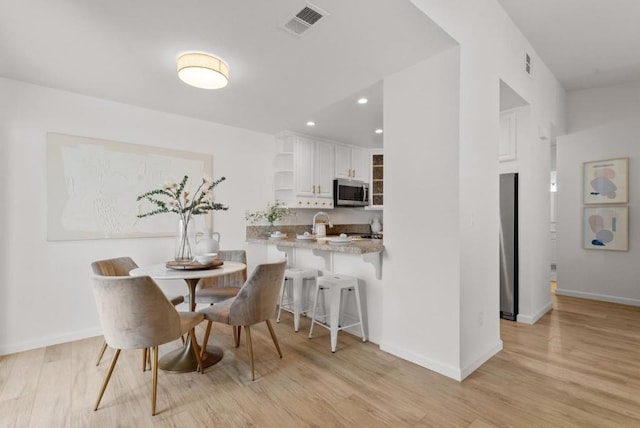 dining space with light hardwood / wood-style floors