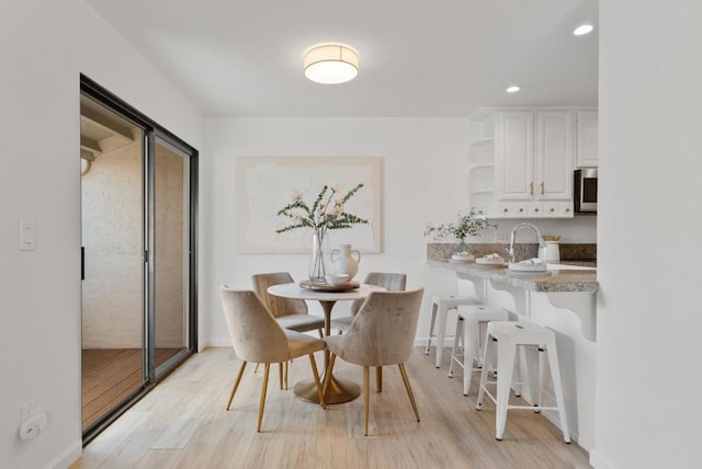 dining area featuring sink and light hardwood / wood-style flooring