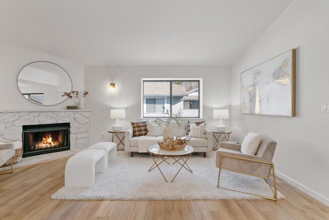 living room featuring hardwood / wood-style flooring and a stone fireplace