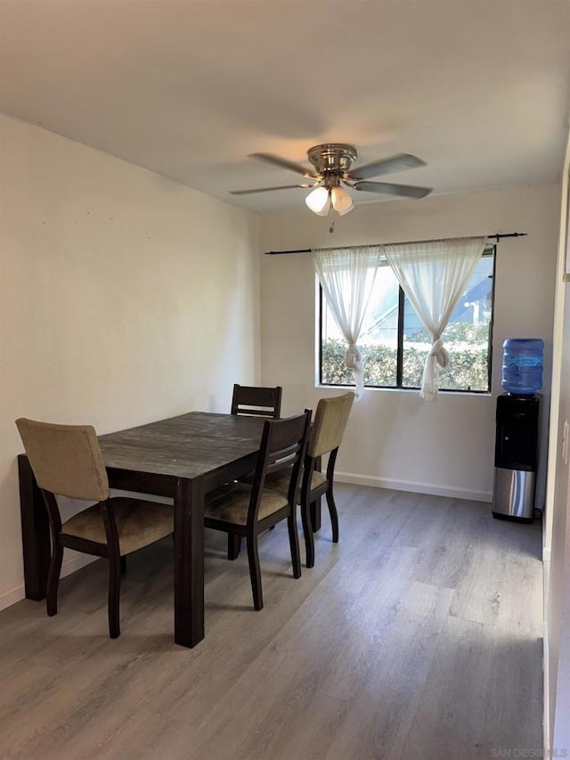 dining space with wood-type flooring and ceiling fan