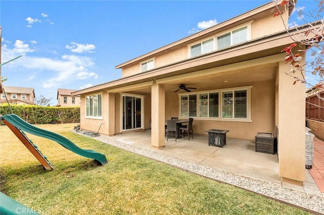 rear view of house with a patio area, a playground, and a lawn