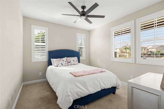 carpeted bedroom with multiple windows and ceiling fan