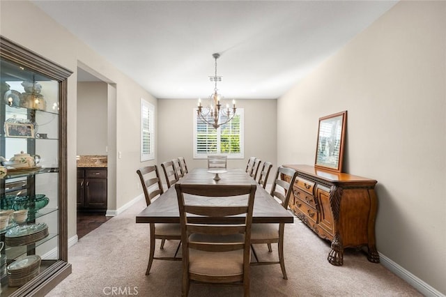 carpeted dining room featuring a chandelier