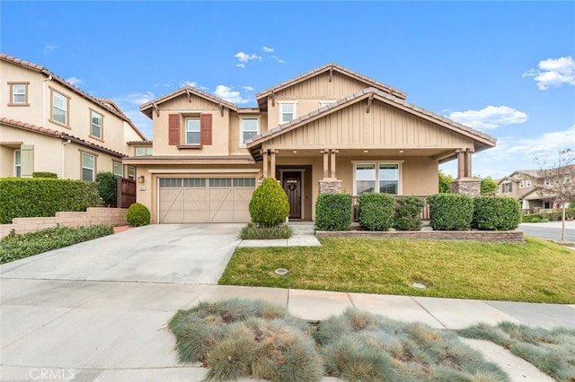 craftsman-style home with a garage, covered porch, and a front lawn