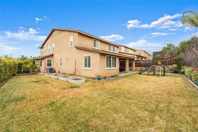 back of house featuring a lawn, a playground, and central air condition unit