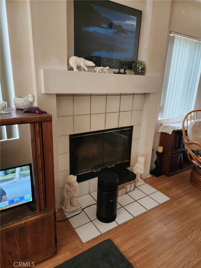 room details with a tiled fireplace and hardwood / wood-style flooring