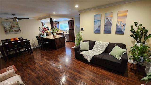 living room with dark wood-type flooring, ceiling fan, and ornamental molding