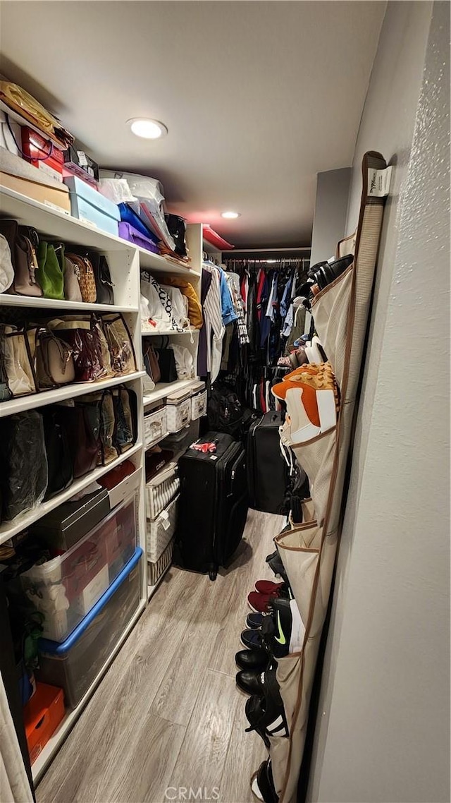 spacious closet with light hardwood / wood-style flooring