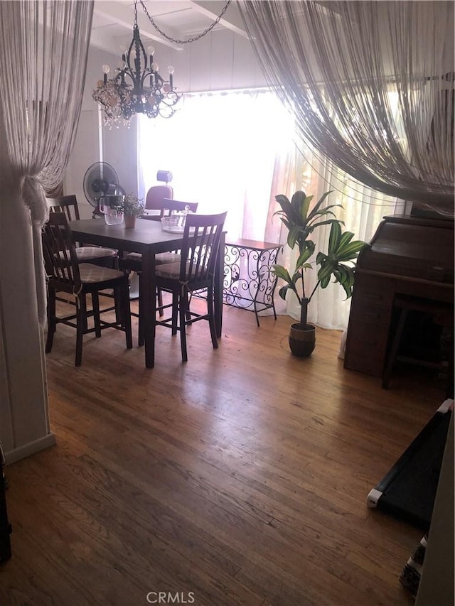 dining room with dark hardwood / wood-style floors and a chandelier