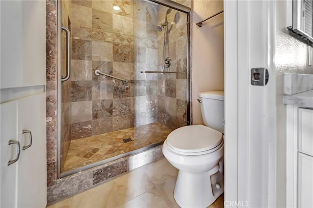 bathroom featuring toilet and an enclosed shower