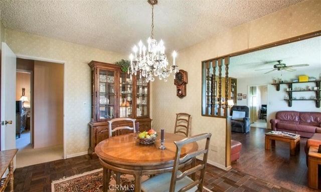 dining space with dark parquet flooring, ceiling fan with notable chandelier, and a textured ceiling