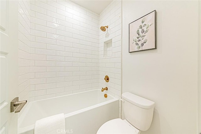 bathroom featuring tiled shower / bath and toilet