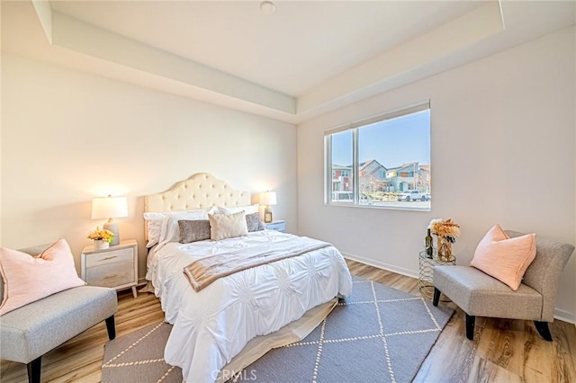 bedroom featuring a raised ceiling and hardwood / wood-style floors