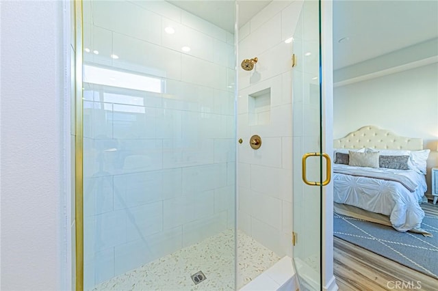 bathroom featuring an enclosed shower and hardwood / wood-style flooring