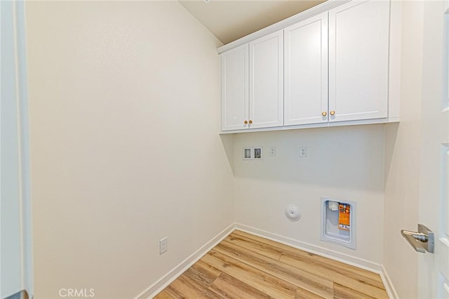 clothes washing area with gas dryer hookup, hookup for a washing machine, light hardwood / wood-style flooring, and cabinets