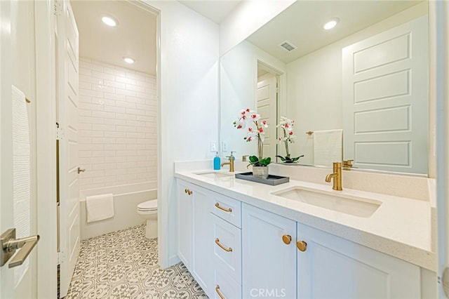 full bathroom with vanity, tiled shower / bath combo, tile patterned floors, and toilet