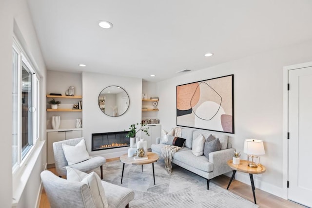 living room with plenty of natural light and light hardwood / wood-style flooring