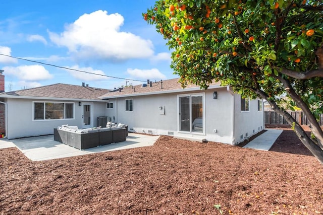 back of property with an outdoor living space and a patio