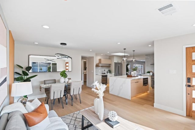 living room featuring wine cooler and light hardwood / wood-style flooring