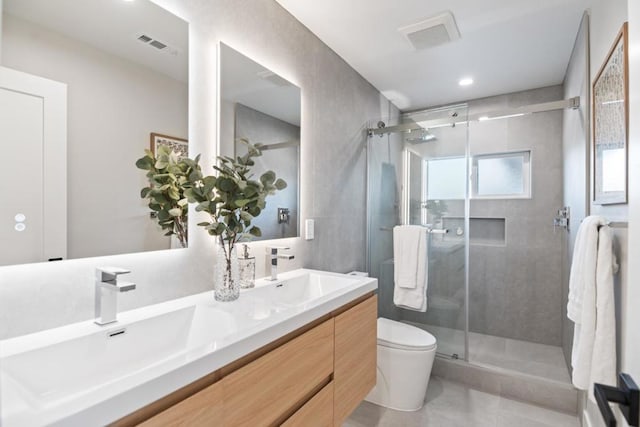 bathroom featuring vanity, toilet, a shower with shower door, and tile patterned flooring