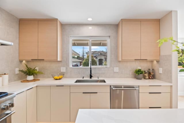 kitchen with tasteful backsplash, stainless steel appliances, light brown cabinetry, and sink