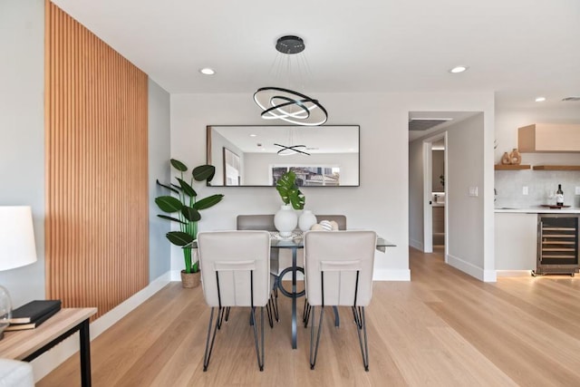 dining space featuring wine cooler and light wood-type flooring