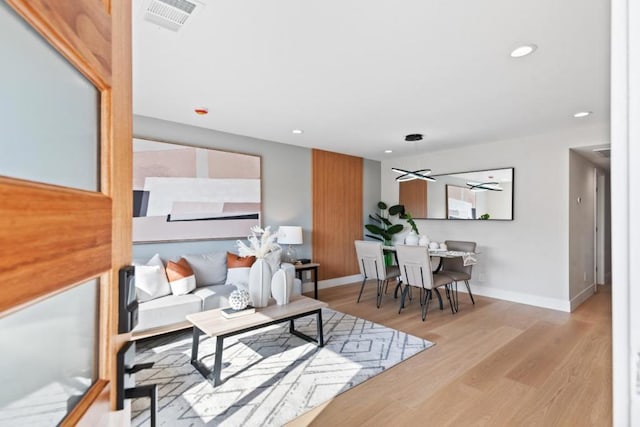 living room featuring ceiling fan and light hardwood / wood-style flooring