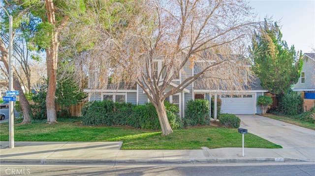 view of property hidden behind natural elements with a garage, concrete driveway, and a front lawn