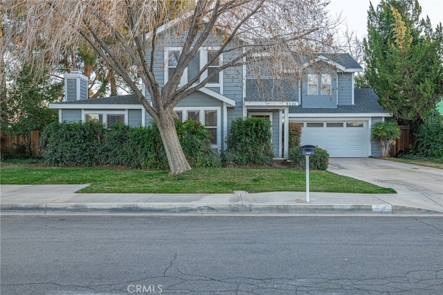 traditional-style house with driveway, an attached garage, and a front yard