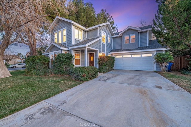 traditional-style home featuring a garage, driveway, and a front yard