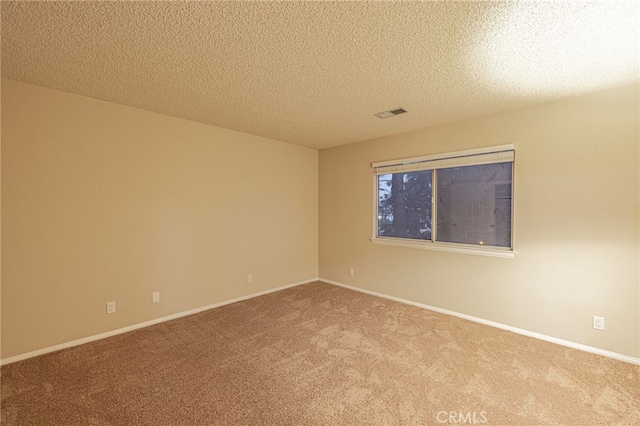 empty room featuring baseboards, a textured ceiling, visible vents, and carpet flooring