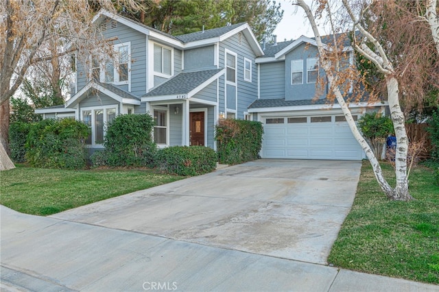 view of front of property with an attached garage, driveway, roof with shingles, and a front yard