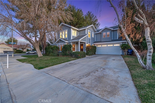 traditional-style house with concrete driveway, a lawn, and an attached garage