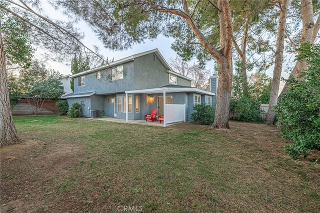 rear view of property with a lawn, a patio area, a fenced backyard, and stucco siding