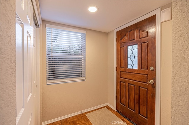 foyer with baseboards and a textured wall