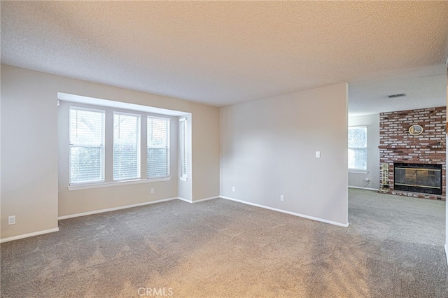 unfurnished living room with a brick fireplace, carpet flooring, visible vents, and baseboards