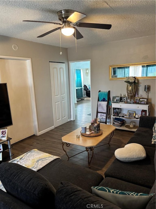 living room featuring a textured ceiling, ceiling fan, and wood finished floors