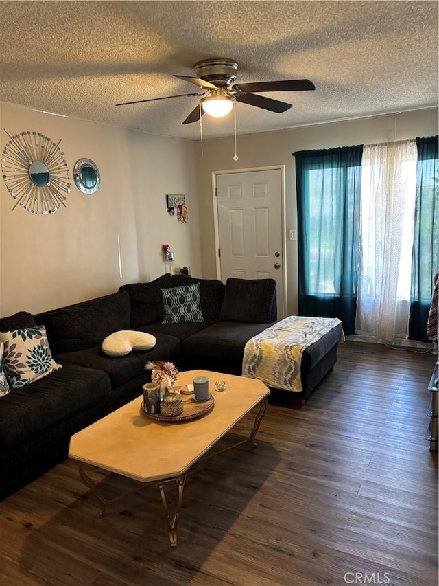 living room featuring a textured ceiling, ceiling fan, and wood finished floors