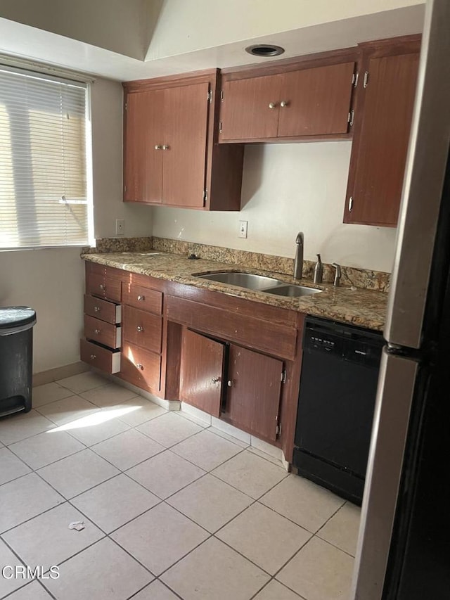 kitchen featuring dishwasher, sink, light tile patterned floors, and stainless steel fridge