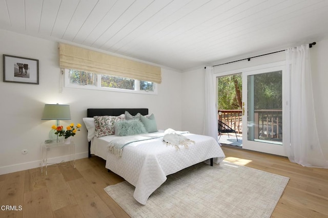 bedroom featuring multiple windows, wooden ceiling, access to exterior, and light wood-type flooring