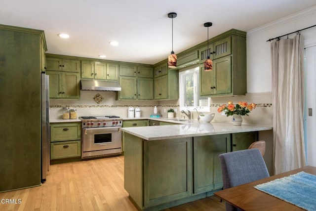 kitchen featuring kitchen peninsula, hanging light fixtures, green cabinetry, stainless steel appliances, and light wood-type flooring